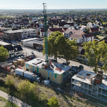 Vue aérienne du chantier Hahnenberg à Châtenois, avec des façades à ossature bois posées sur une partie des bâtiments.